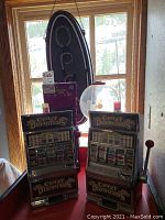 Group shot showing neon OPEN sign hanging, purple mini arcade game, red tabletop gumball machine and two Crazy Diamonds slot machines