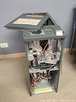 Furnace front panel open showing internal wiring and components