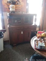 Full front view of the oak English hutch showing upper glass cabinet, drawers, and lower doors with decorative wood detailing.