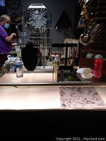 Photo showing black velvet bust and bar necklace displays with assorted necklaces including beads and pendants, some metallic.