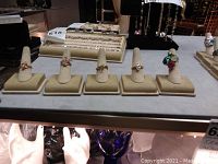 Overview of five 925 sterling silver rings on beige fabric holders, showing multiple ring designs and gemstone colors.