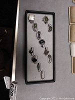 Full view of all 12 rings placed in a display tray, showing varied stone colors and ring designs.