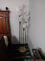 Full view of floor lamp showing six calla lily shades on tall brass rods