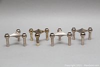 Four mid century atomic style chrome taper candle holders in a row, showing front and angled view.