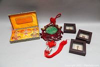 Full lot view showing all items: boxed mini kites, lacquered Buddha wall hanging, and three shadow box frames.