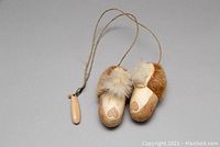 Pair of vintage Native American newborn suede baby shoes with fur trim and an 18-inch hanging cord with a carved wooden bead.