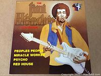 Front cover of vinyl album The Jimi Hendrix Collection featuring an illustration of Jimi Hendrix playing guitar and listing some featured songs.