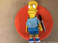 Full body image of the Bart Simpson doll next to a black marker for scale, showing the doll in blue clothing and shoes.