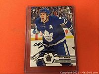 Front of card in protective plastic sleeve, showing player image and autograph