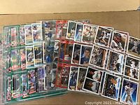 Spread of baseball cards in protective sleeves, showing a variety of various players and card types.