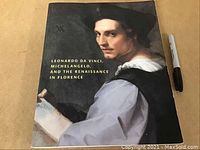 Front cover of the softcover book showing a Renaissance painting portrait of a man, title in yellow text.