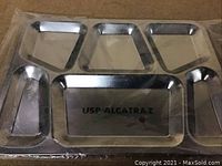 Metal serving tray with "USP ALCATRAZ" stamp and multiple compartments for food separation.