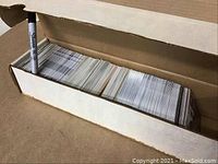 Open box filled with over 500 hockey cards stacked tightly in rows, showing card edges and some card fronts beneath.