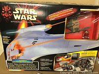 Front of original box showing artwork, branding, large starship profile and windowed compartment with accessories