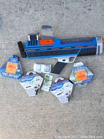 Photo showing Xploderz water ball gun with five unopened packs of water ball ammo and instruction pamphlets spread around the gun.