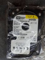 Front label of Western Digital WD400 hard drive showing 40GB capacity and model information in sealed package.