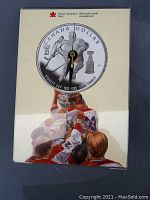 Acrylic clock with Royal Canadian Mint Canada Dollar coin face and hockey player art on base