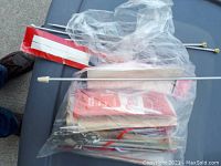Photo showing a variety of metal knitting needles, some in plastic packaging and others loose, all laid out on a surface, illustrating the lot's contents.
