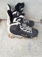 Side view of black and white Nike roller blades showing wear and yellowed wheels