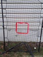 Pitch back net with metal frame and black netting, red square strike zone in the center