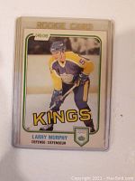 Front of 1981-82 O-Pee-Chee Larry Murphy rookie card in protective case showing player image and team name Kings.