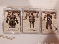 Image of three black-and-white Parkhurst hockey cards in individual plastic cases showing players Hainsworth, Morenz, and Vezina on the ice with their names displayed on each card.