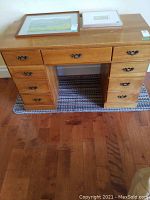 Front view of wood desk showing 8 drawers and wood grain finish