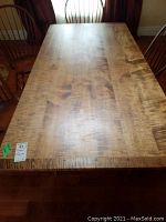 Rectangular wooden dining table top with visible curly figure grain
