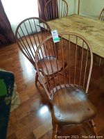 Four Windsor style chairs around table, two facing camera, showing overall set and finish
