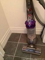Full view of upright vacuum with floor head attached on tiled floor