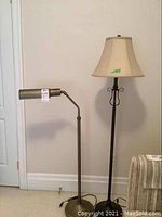 Two floor lamps shown side by side against a wall. The one on the left is an adjustable metal floor lamp about 42.5 inches tall. The one on the right is a taller metal floor lamp with a beige cloth shade about 58 inches tall.
