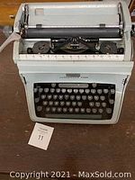 Front view of light blue manual typewriter showing keyboard and paper feed area with 'Underwood Five' brand visible.