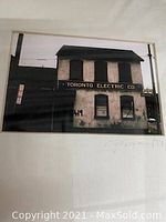 Framed black and white photo of Toronto Electric Co. building with visible signage and aged wear.