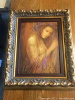Full frontal of framed giclée artwork showing portrait of woman in gilt frame
