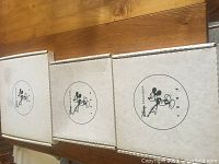 Three white rectangular cardboard boxes featuring vintage Mickey Mouse logos and 'Disney Treasures 1994' label, used for packaging the prints.