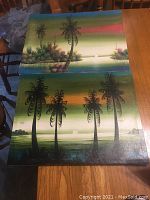 Two original colorful paintings by D. Roberts depicting tropical landscapes with prominent palm trees and gradient sky backgrounds, colors ranging from greens to pinks and blues.