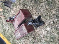 Photo showing two red metal vehicle ramps positioned on grass alongside three metal scissor car jacks with wear from use.