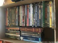 Box of DVDs with spines showing various movie titles arranged side by side.