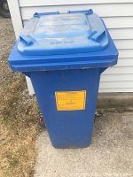 Front view of one blue recycling container with yellow label on front and lid closed.