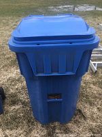 Front view of large blue recycling container with lid closed.
