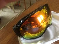 Scott ski goggles with reflective orange-yellow lens on a white cloth bag, showing lens and case condition.
