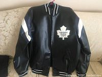 Front view of jacket showing Toronto Maple Leafs chest logo, rib-knit collar and welt pockets