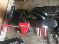 Photo showing Rockit Fitness push up assist machine with black padded seat and red handles, leg stretcher partially shown behind