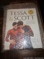 Photo of the book "Tessa & Scott" covered in bubble wrap showing the front cover with the title and the image of two ice skaters.