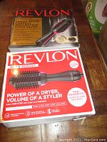Two boxed Revlon Salon One-Step hair dryer and volumizer units, showing product packaging with brand, model, and feature highlights.