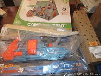 NERF Elite 2.0 Shockwave blaster, partially wrapped wooden sword and assembled camping tent box in star printed packaging