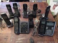 Panasonic cordless phones arranged on table showing two main bases with digital displays and multiple handsets with charging bases