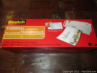 Box front of Scotch Thermal Laminator showing product image and details including size and starter pouch
