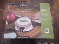 Box front of iDevices Kitchen Thermometer with image of device, Bluetooth connected thermometer text, cooking essential info block, and app reference.