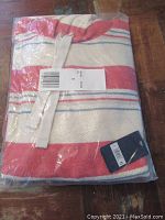 Loop Terry Baja sweater still folded in plastic packaging, showing color and tag